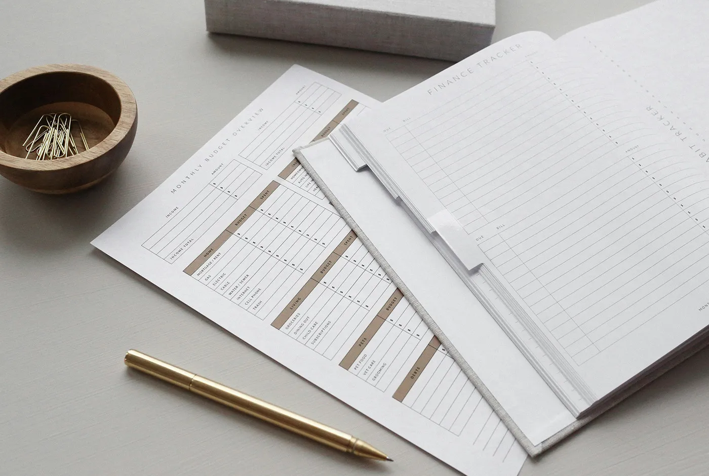 Ausgedruckte monatliche Budgetübersicht und ein Finanzplaner mit Stift auf einem Schreibtisch